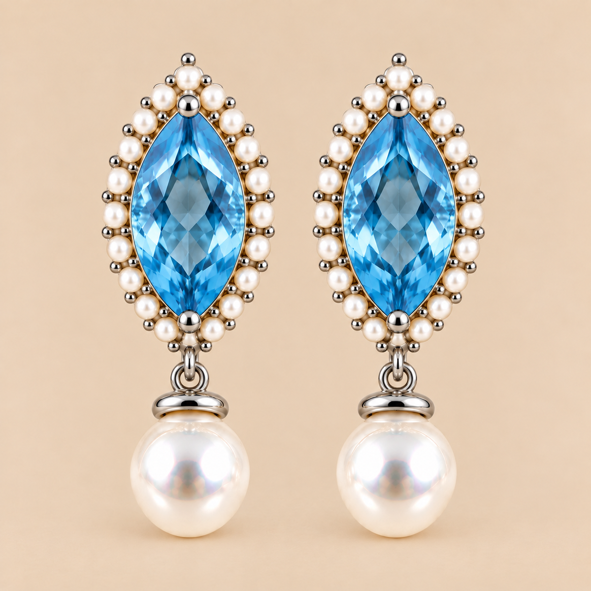 A pair of drop earrings featuring marquise-cut swiss blue topaz surrounded by small white pearls and silver-toned beads, with round white pearl drops below, set against a solid beige background.