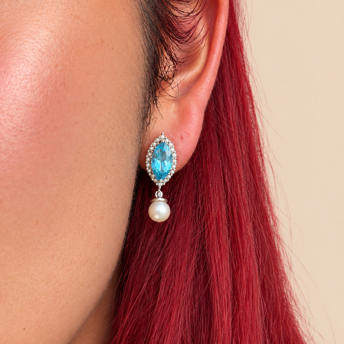 Drop earrings featuring marquise-cut swiss blue topaz surrounded by small white pearls and silver-toned beads, with round white pearl drops below